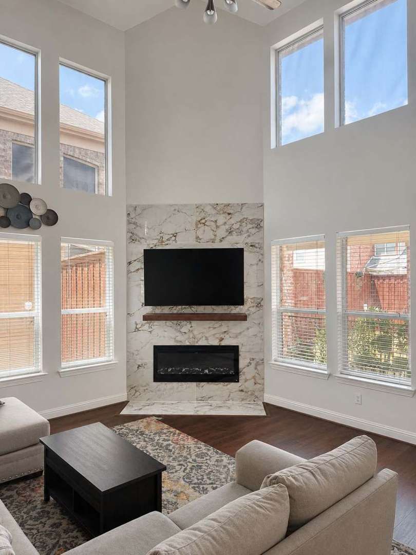 Floor-to-ceiling marble-look large-format porcelain fireplace wall in a DFW living room